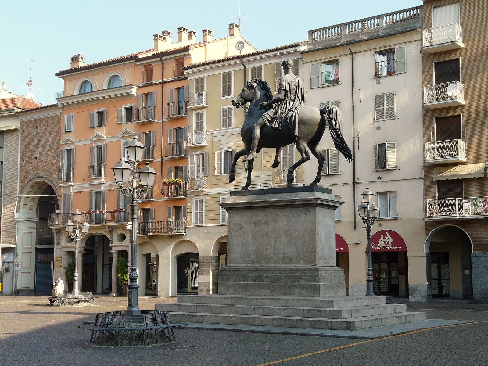 Piazza Mazzini a Casale Monferrato con il monumento equestre a Carlo Alberto davanti a palazzi colorati con i portici
